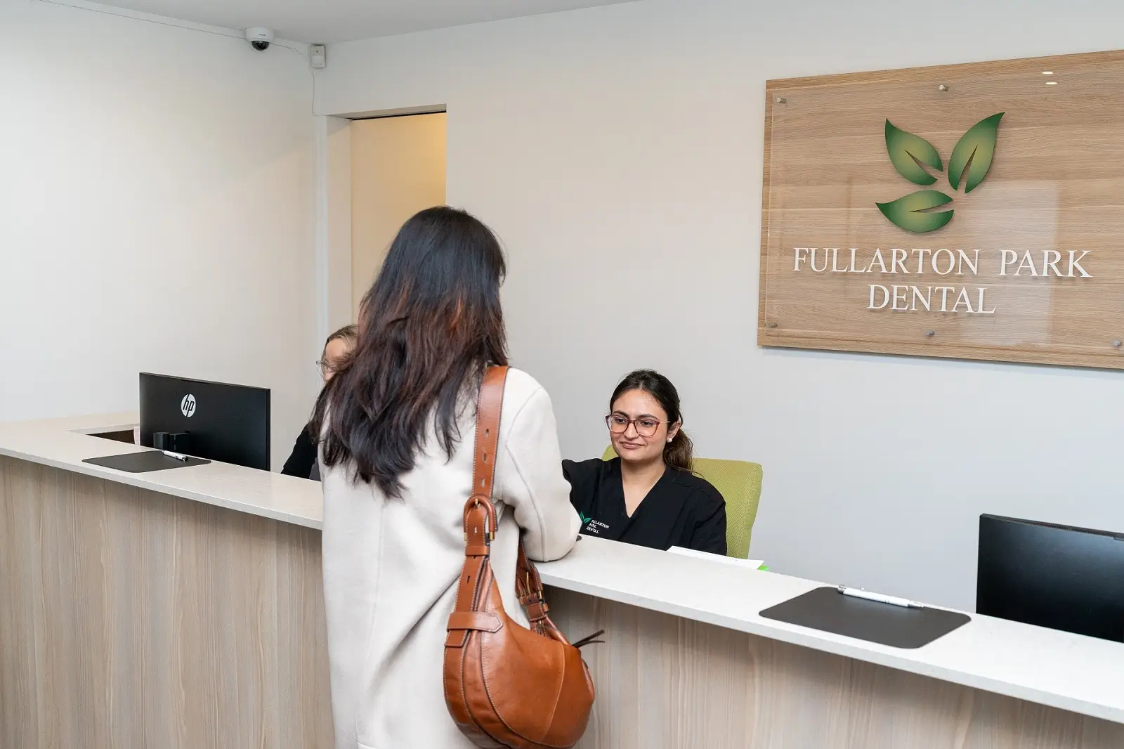 A patient being welcomed at the Fullarton Park Dental reception desk